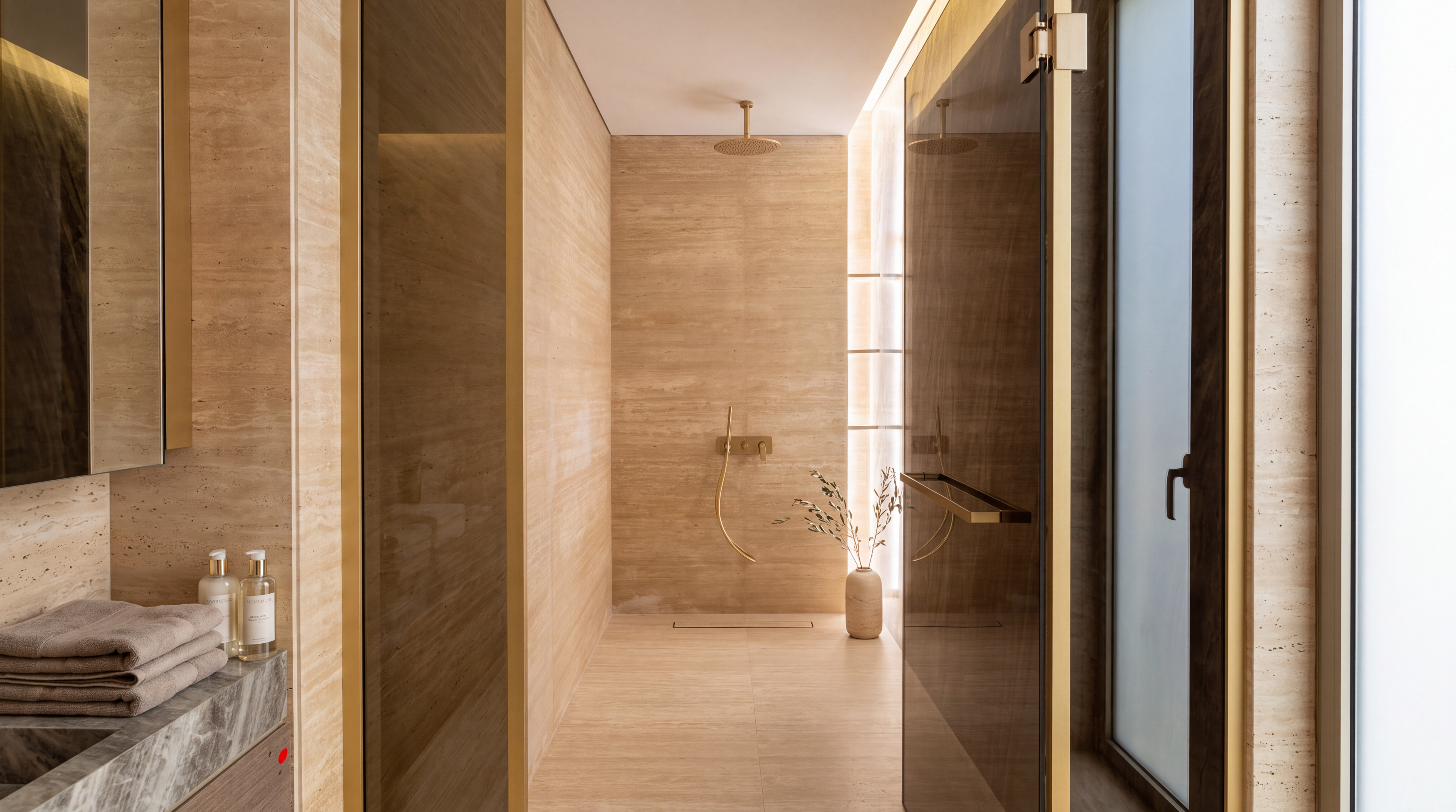Serenia Living bathroom suite with travertine finishes and gold fixtures